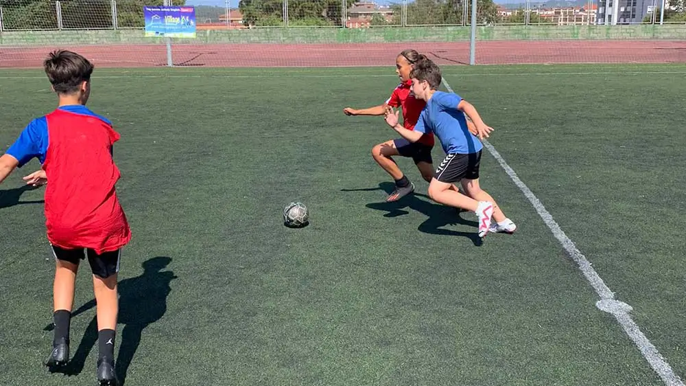 Jeunes profitant d’un entraînement de football au camp d’été en anglais the Village