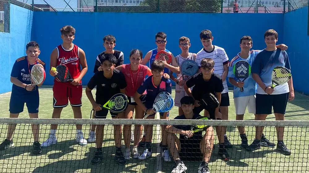 Jeunes joueurs avec leur coach international sur un court de padel au camp d’anglais the Village