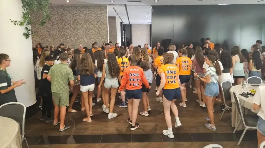 Junge Teilnehmer des internationalen Camps tanzen im Hotelsaal