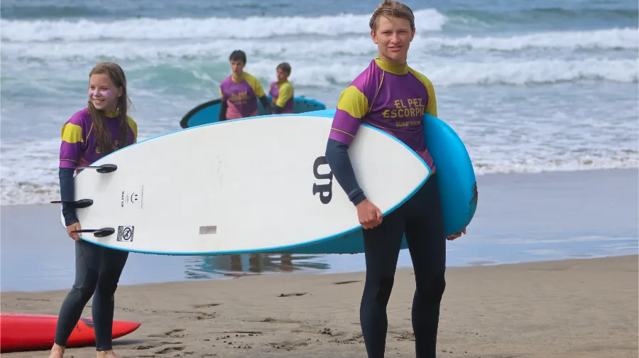 Zwei Jungen kommen nach der Surfstunde im Camp the Village mit ihren Brettern aus dem Meer