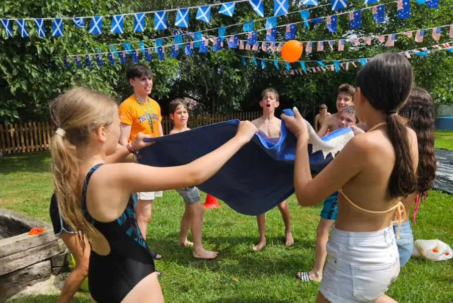 Jóvenes participantes en el campamento de verano en inglés juegan en una actividad al aire libre