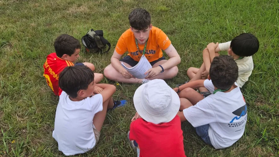 Cinco chicos en el campamento en inglés the Village conversan con su coach internacional