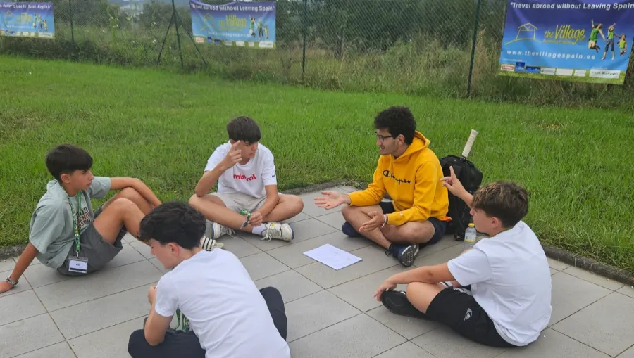 Grupo de adolescentes conversan con su coach internacional - the Village