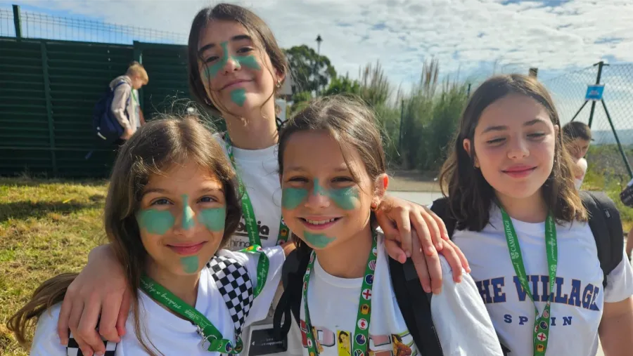 Cuatro chicas con la cara pintada disfrutan en el campamento internacional the Village