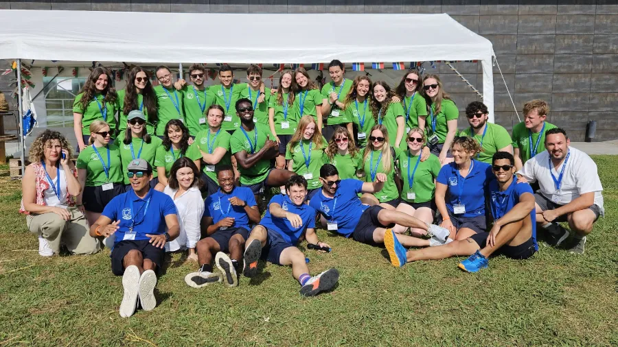 Groupe d'entraîneurs du camp d'été en anglais the Village posant devant l'hôtel