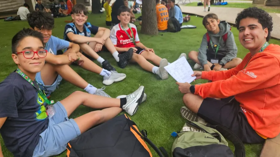 Cinco jóvenes participantes del campamento internacional en una sesión con un coach internacional