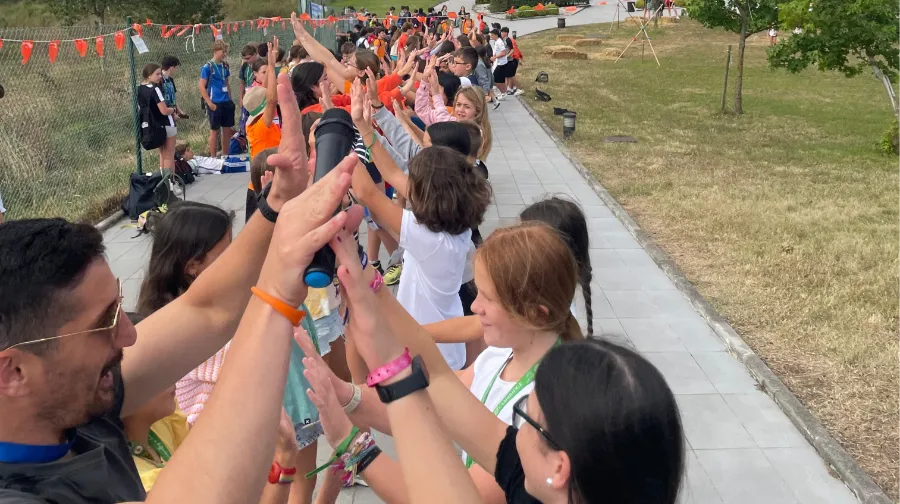Group of teenagers with their international coaches welcome fellow campers