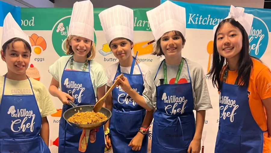 Vier Teilnehmer zeigen ihr Gericht in der Village Chef Aktivität - Sommercamp