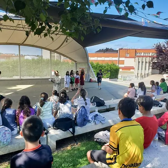 Gruppe von Kindern beobachtet eine Vorstellung im Amphitheater des Sommerlagers in Spanien