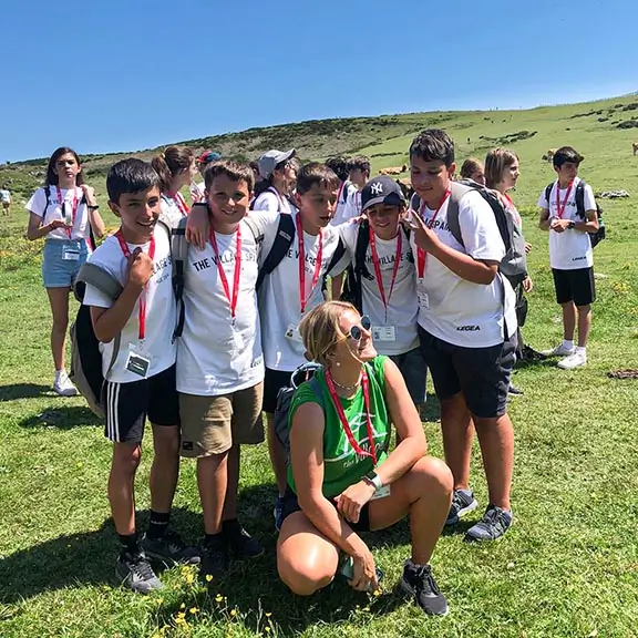 Eine Gruppe von Kindern an einem sonnigen Tag bei einem Ausflug in die asturischen Berge mit ihrer englischen Coach