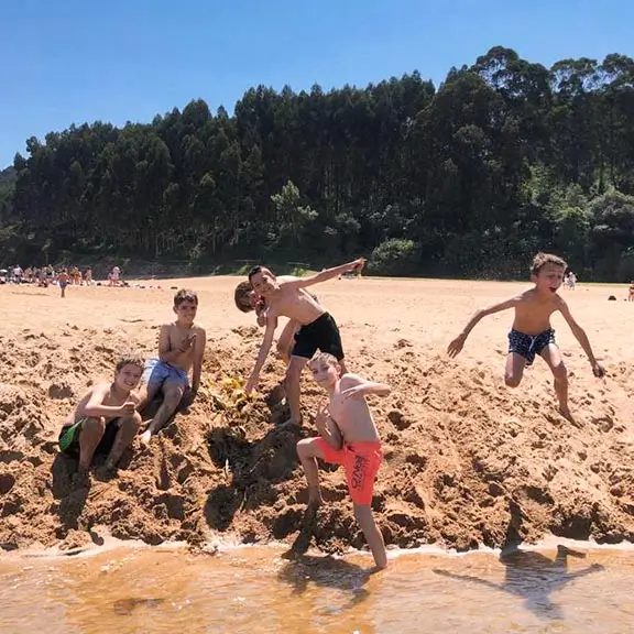 Kinder spielen am Strand im internationalen Sommerlager in Spanien