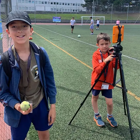 Zwei Kinder der Media-Aktivität filmen ihre Freunde während der Fußball-Aktivität