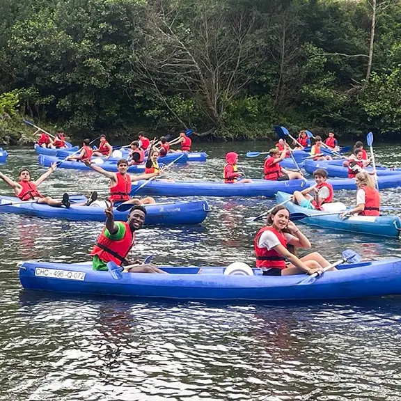 Teilnehmer beim Kajakfahren auf dem Fluss Nalón im Sommerlager