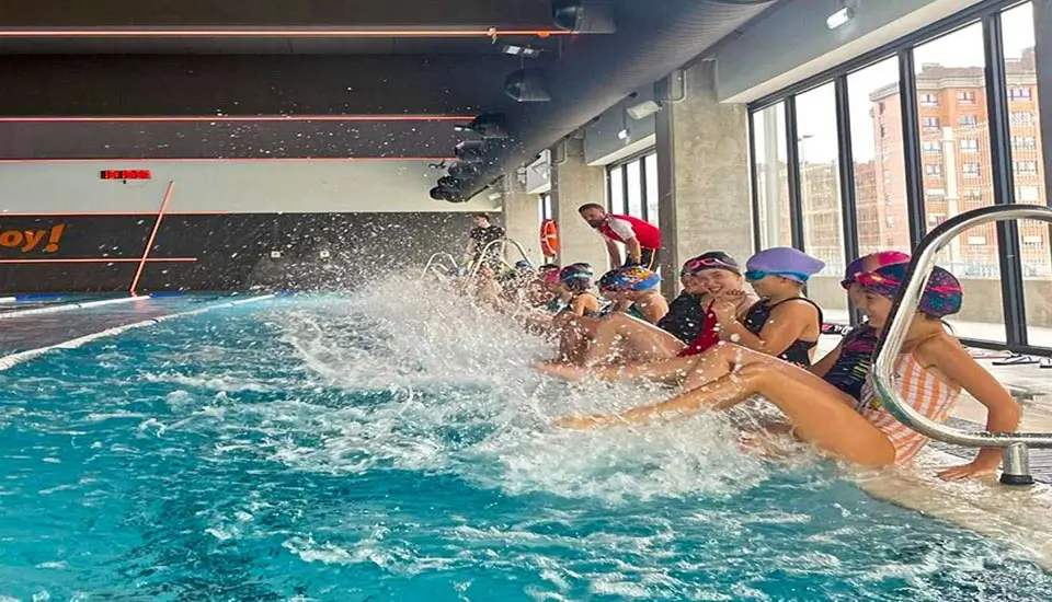 Gruppe von Kindern spielt im beheizten Schwimmbad des Sommercamps für Kinder in Spanien