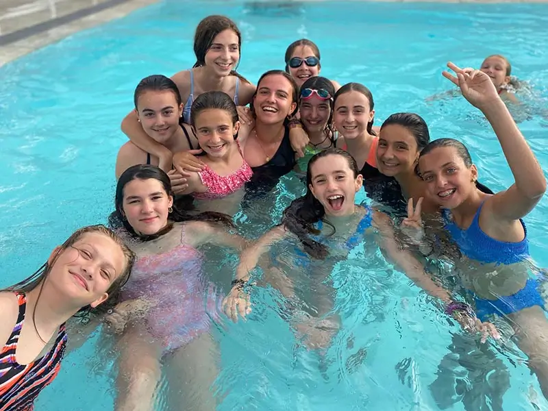 Eine Gruppe Jugendlicher im Pool mit internationalen Trainern im Sommercamp in Spanien the Village