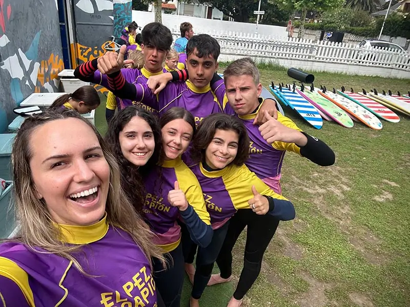 Teilnehmer des Englisch Sommercamp in Spanien bereiten sich mit ihrem Coach auf die Surfstunde vor