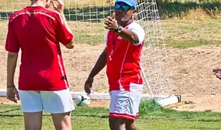 Certified trainers leading a soccer training session at the English camp.