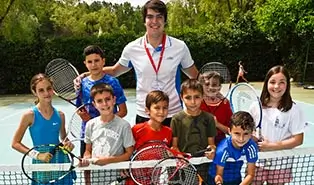 Experienced trainers leading a tennis session at the English camp.