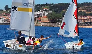 Summer camp in Spain: children practicing sailing in the Cantabrian Sea safely.