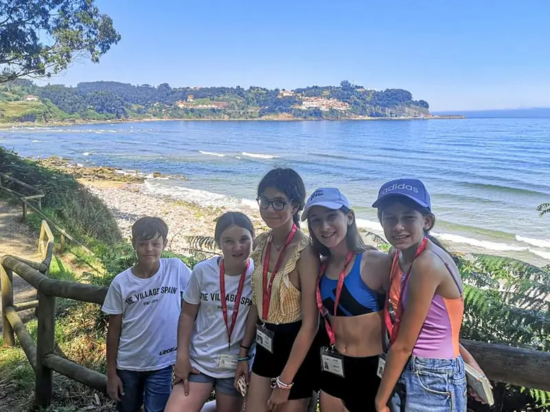 Five children on an excursion along a path on the Asturian coast