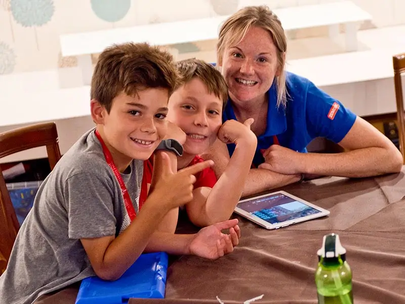 Two kids with their English coach during the Media activity at the international summer camp in Spain the Village