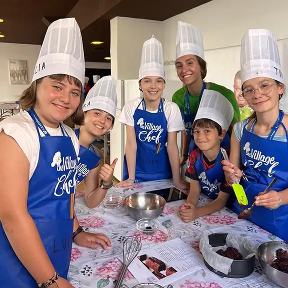 Grupo de participantes en la actividad Cooking del campamento de inglés con su coach internacional.