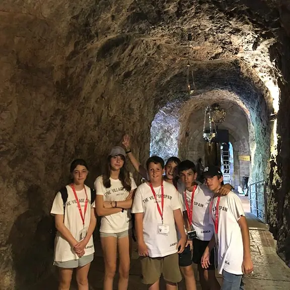 Un grupo de chicos en una cueva durante una excursión en el campamento de inglés