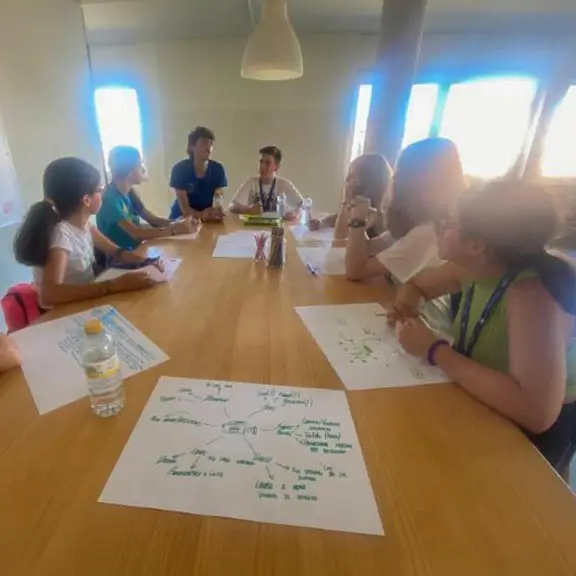 Grupo de chicos recibiendo instrucciones de su coach angloparlante en la actividad de Media