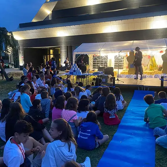 Participantes disfrutando de una actividad nocturna en el campamento de verano en inglés the Village