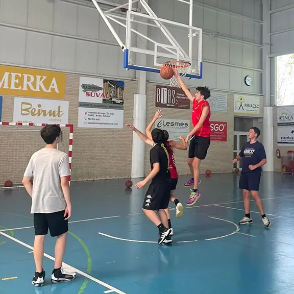 Grupo de chicos entrenando basketball con coaches internacionales en el campamento