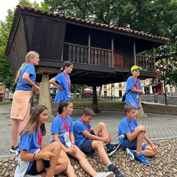 Jóvenes participantes en el campamento inglés en España the Village frente a un hórreo, una construcción típica asturiana