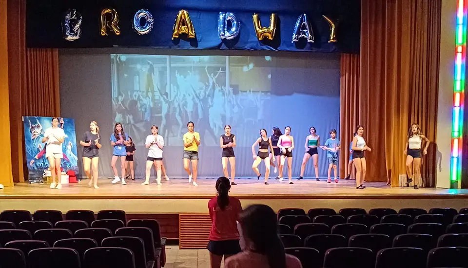 Participantes en la actividad de danza durante una actuación en el teatro del campamento inglés en España