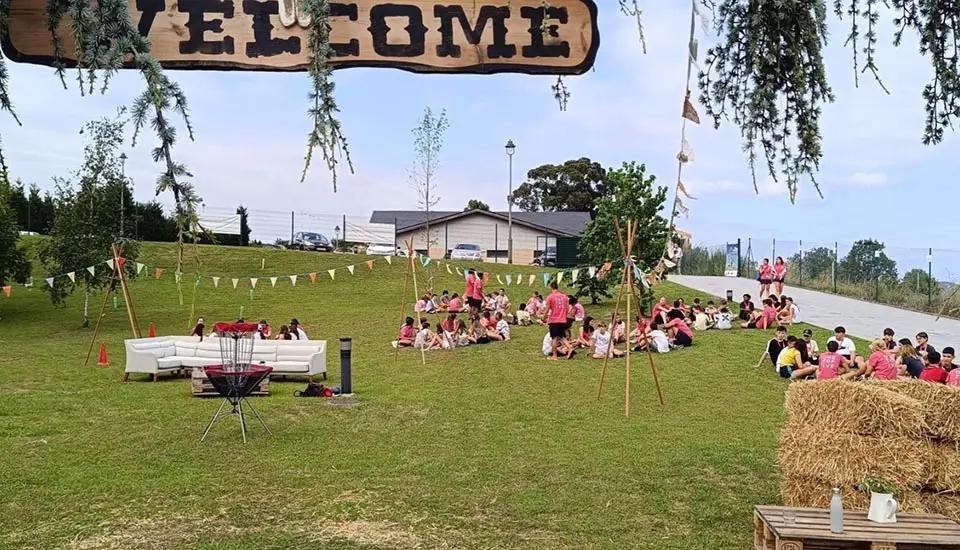 Participantes en el campamento inglés en España conversan con sus coaches angloparlantes antes de la cena barbacoa