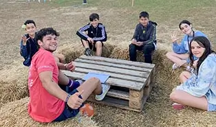 Coach bilingue discutant avec un groupe de participants au camp de vacances en anglais the Village