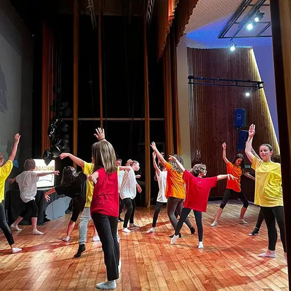 Groupe de filles préparant une représentation théâtrale dans la colonie internationale en anglais