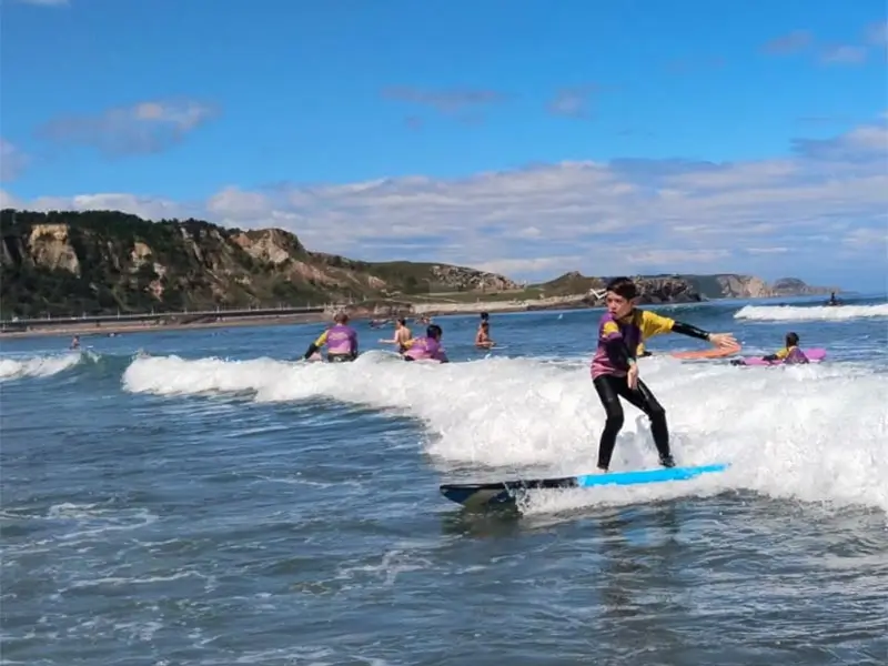 Un jeune pratiquant le surf sur la plage de Salinas au camp de vacances en anglais the Village