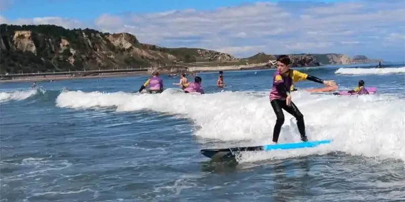 Joven practicando la actividad de Surf en la playa de Salinas