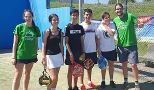 Allenatori bilingui che dirigono una sessione di padel in strutture di alta qualità in un campo in inglese.