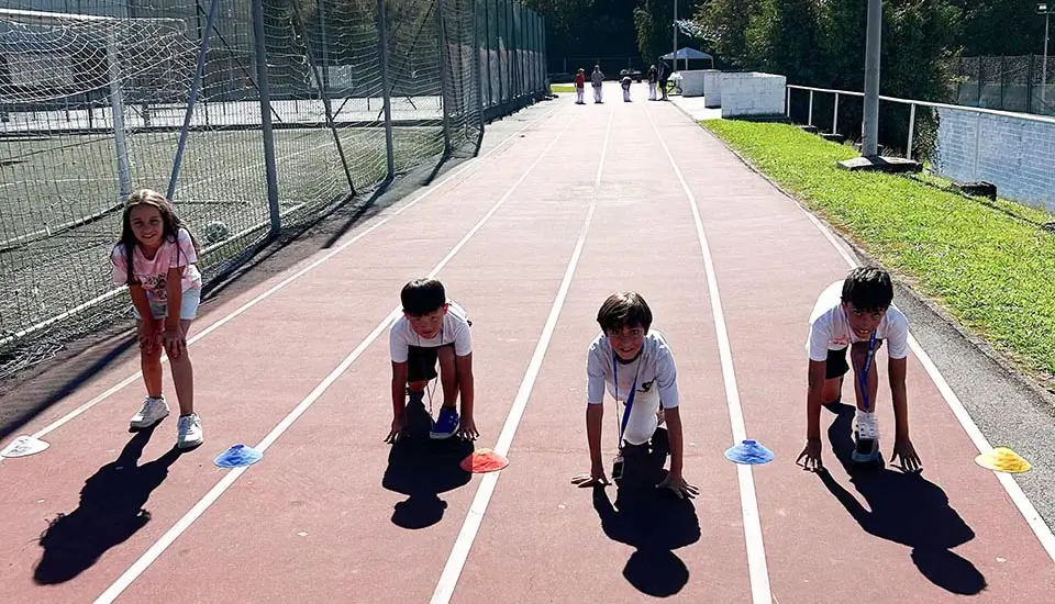 4 bambini sulla pista di atletica del campo in inglese in Spagna