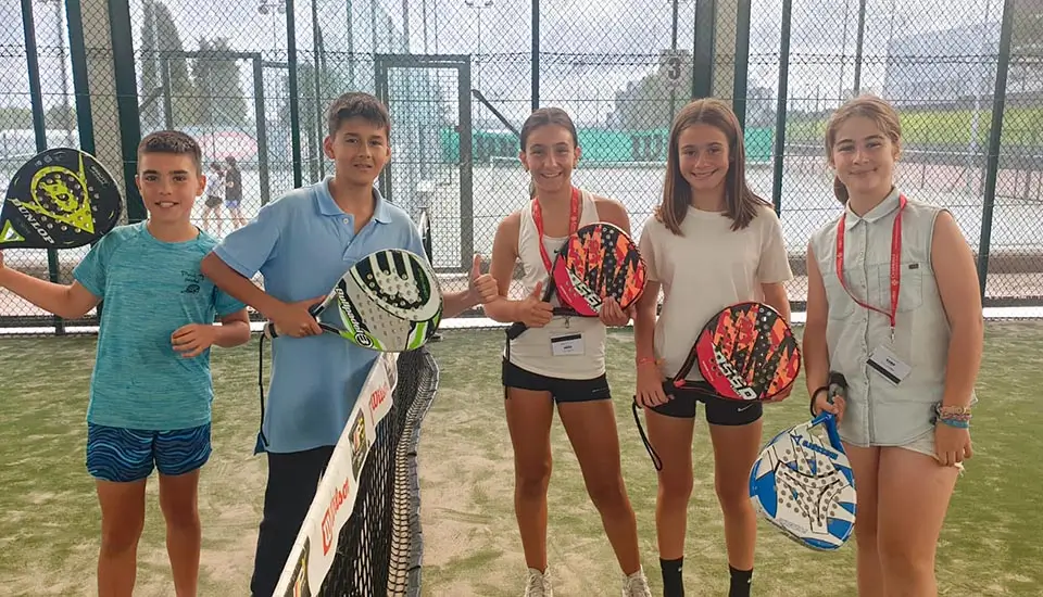 Gruppo di giovani partecipanti su uno dei campi da padel coperti al campo in inglese in spagna